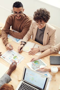 pexels photo 3184287 3184287 A diverse team of professionals collaborating over charts and graphs during a business meeting.